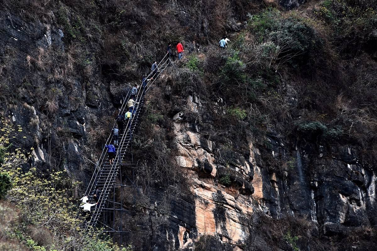 告别“悬崖村” 下钢梯上楼梯 “悬崖村”12日起陆续搬迁