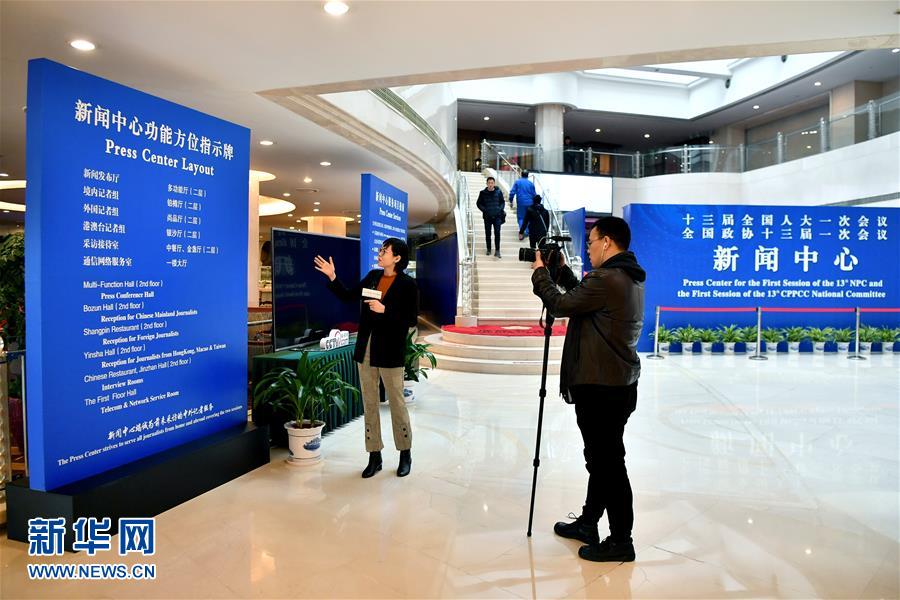 2月27日，两名记者在全国两会新闻中心内采访拍摄。新华社记者 李鑫 摄