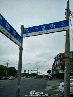 在凯旋路和一匡街交汇的电线杆下,旁边蓝底白字的路牌一匡路英文却