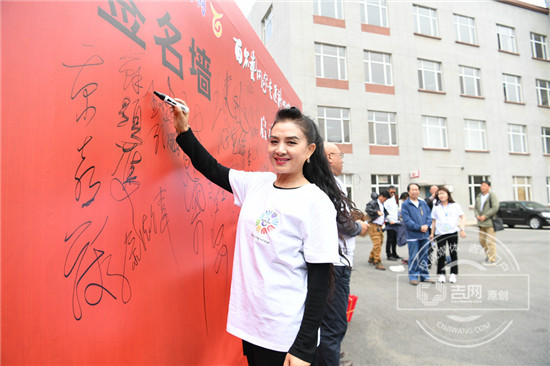 艺术家王小燕在签名墙上签字
