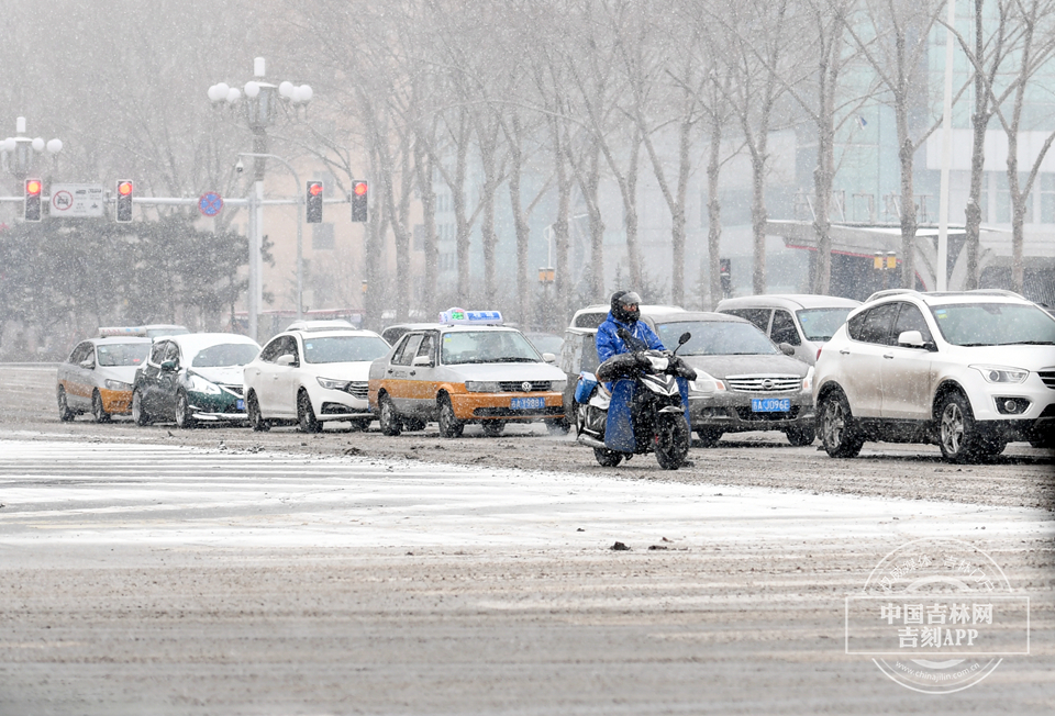 在南湖大路与人民大街交会处,积雪已经融化的地面再次被降雪所覆盖