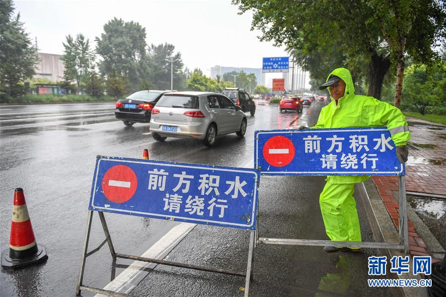 9月3日,在長春市世紀廣場附近易積水點,防汛工作人員設立警示標誌.