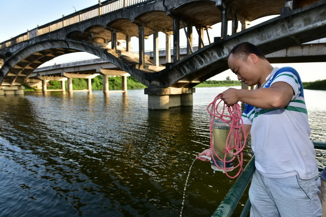 环保监测人员在提取水样。摄影/章轲