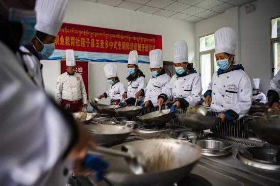 西藏玉麦乡搬迁群众在学习烹饪技术(7月30日摄).