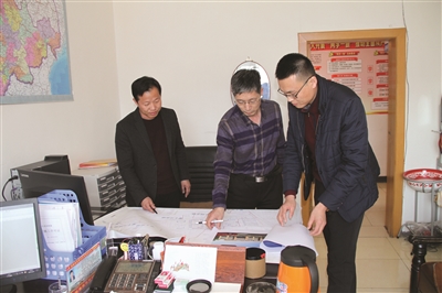 易地扶贫搬迁领导小组成员正在研究新区规划图 易地扶贫搬迁领导小组成员正在研究新区规划图