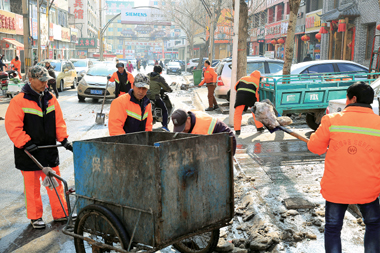 环卫工人以班组为单位，进行精细化作业，清理冰雪及垃圾。