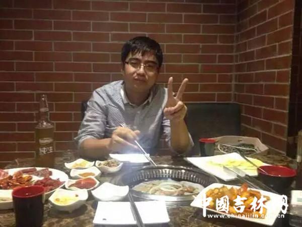 宋巍在餐桌前吃饭,左手做出“剪刀手”