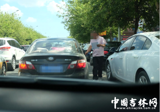 粉T恤拿着“车证”返回车里 粉T恤拿着“车证”返回车里