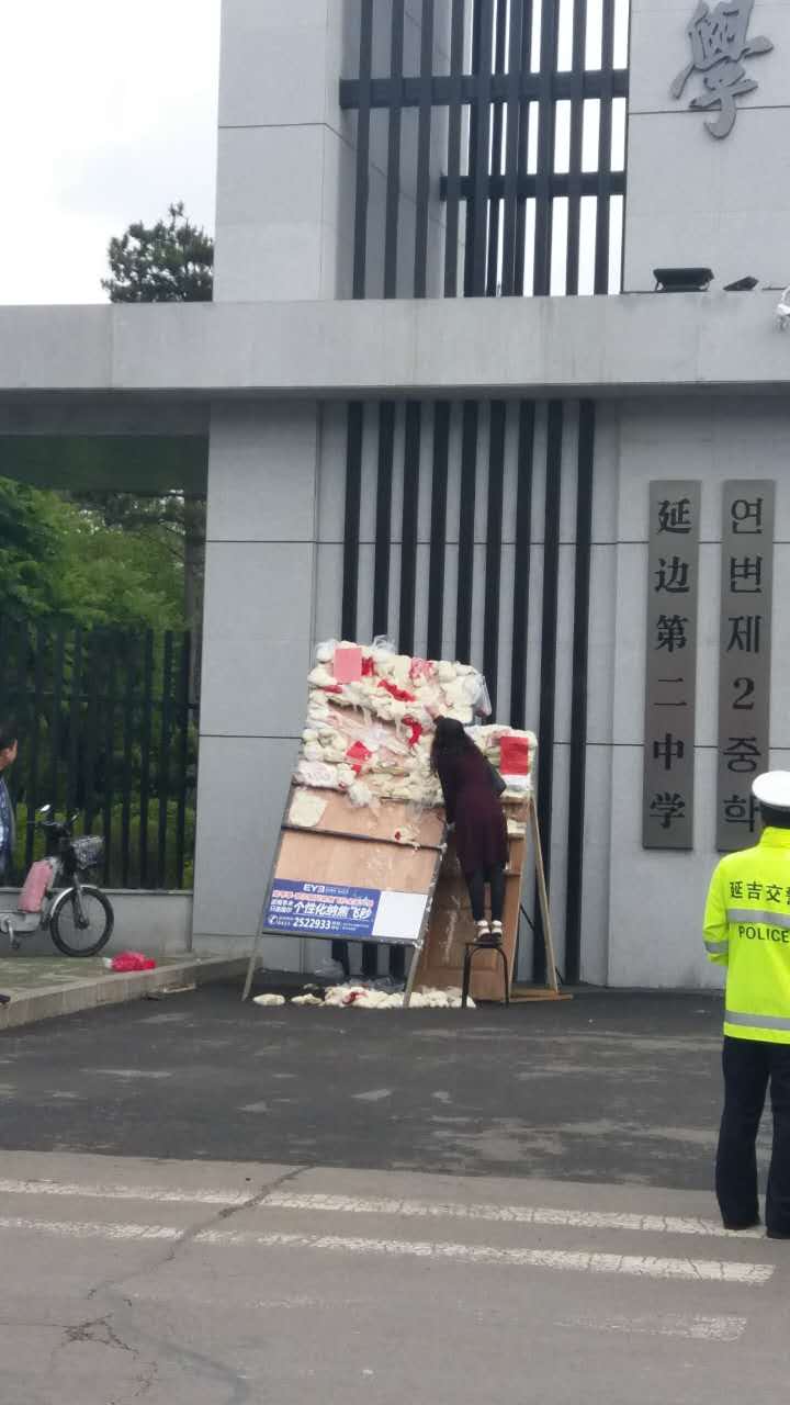 在延边二中考点,刚刚赶来的家长正在努力把打糕贴在门板上,期望考生打高分。 在延边二中考点,刚刚赶来的家长正在努力把打糕贴在门板上,期望考生打高分。