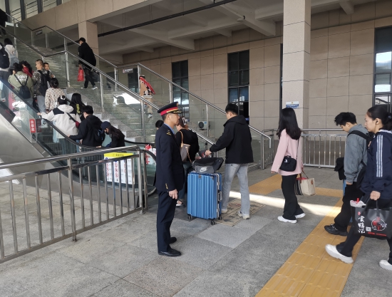 3.长春车务段扶余北站客运员在扶梯处引导防护 摄影：殷秋野.jpg