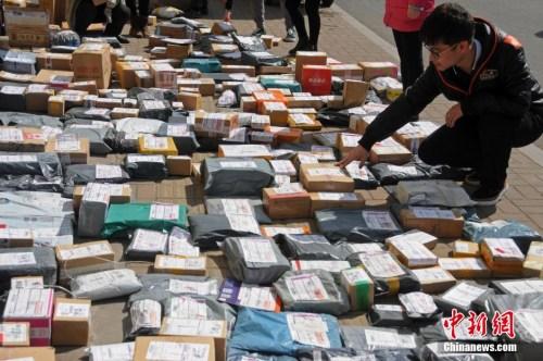 资料图:山西太原一高校外,学生们在地摊上找寻各自的快递。武俊杰 摄 资料图:山西太原一高校外,学生们在地摊上找寻各自的快递。武俊杰 摄